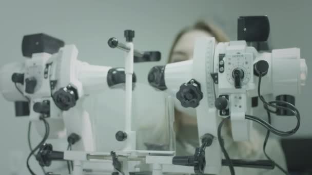 Patientin überprüft Sehkraft in der Augenarztpraxis. Heilt die Augen, stellt die Sehkraft wieder her. Ein medizinisches Gerät zur Überprüfung des Sehvermögens. Arzt arbeitet mit Patienten-Sehtest. — Stockvideo