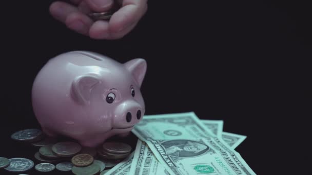 Un homme met une pièce dans une tirelire. Garde de l'argent ou épargne à la maison. La main met les finances dans la fente. Investir de l'argent dans l'avenir. Stocks et prêts préservant la valeur de l'argent. — Video