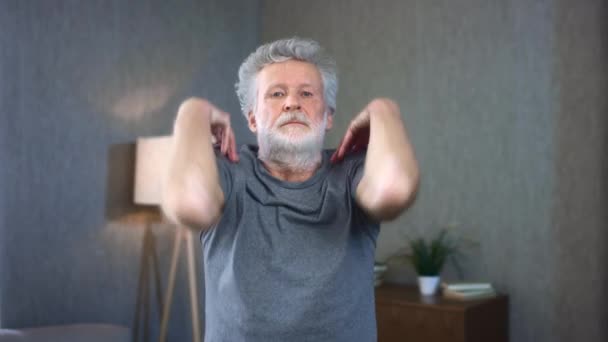 Retrato de un anciano canoso haciendo un ejercicio sobre los hombros. Inicio movimientos deportivos por los compuestos de espalda. Abuelo en excelente forma de cuerpo atlético. Viejo en ropa deportiva. — Vídeo de stock