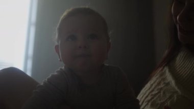 Genç Millennial annesi ve küçük oğlu yatakta. Çocuk kameraya bakıyor, gülümsüyor. Aile değerleri. Doğum izni, ev konforu