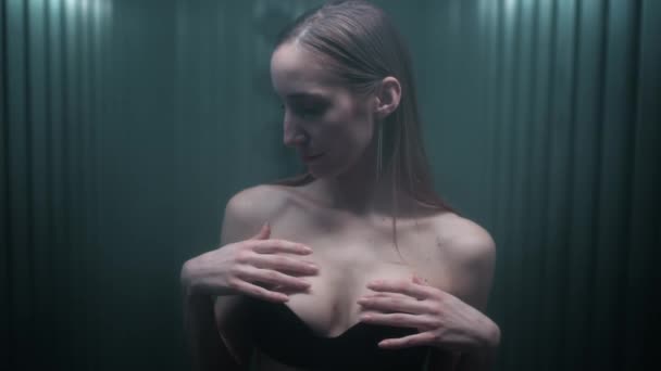 Attractive sexy slim brunette girl touches her tits, collarbone and neck with her fingers. Portrait of a naked skinny female young woman in the studio. Flirts with the camera. Portrait Fashion video — Vídeo de Stock