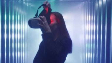 Şirin Kız gözlerine sanal gerçeklik kulaklığı ya da miğfer takar ve bu deneyimden zevk alır. Büyütülmüş gerçeklik gözlüklerinin içine bakıyor. Stüdyoda neon ışığı var. Dijital sanat, daldırma