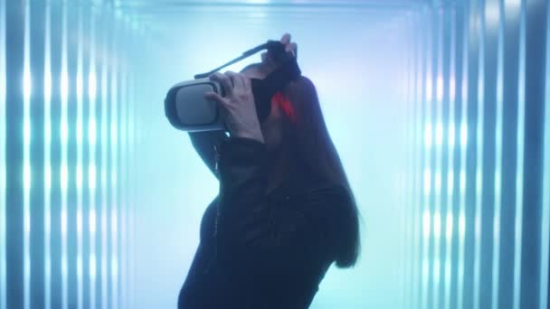 Flickan håller virtuella verklighets glasögon i sina händer, sätter dem på huvudet. — Stockvideo