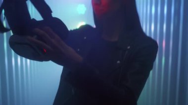 Kız sanal gerçeklik gözlüğünü elinde tutuyor ve kafasına takıyor..