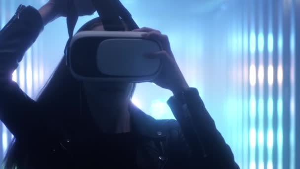 Una hermosa joven se pone gafas de realidad virtual en la cabeza. — Vídeos de Stock