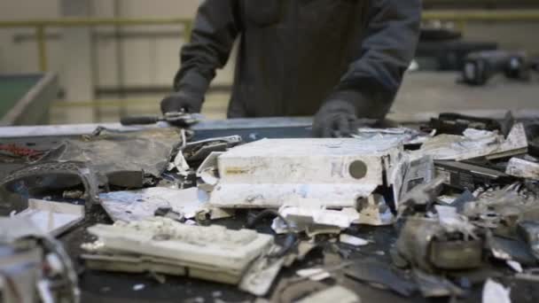 Een mannelijke werknemer sorteert en recycleert elektronisch afval en schroot. — Stockvideo