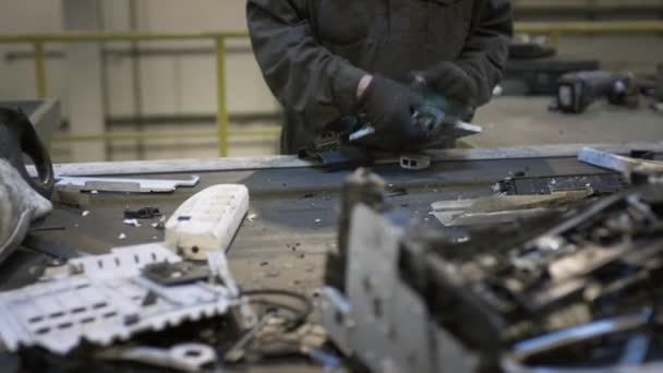 Een mannelijke werknemer sorteert en recycleert elektronisch afval en schroot. — Stockvideo