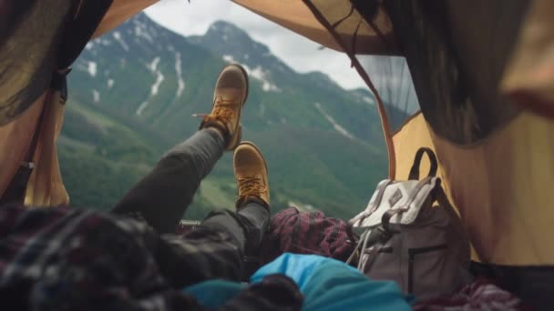 黄色のブーツのハイカーの女性の足は黄色のテントの中にあります。旅行者の足が休んでいる、少女は嘘をつき、登山後に山を賞賛します — ストック動画
