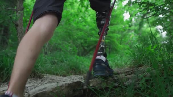 Männlicher Wanderer mit Beinprothese. Knie und Fuß prothetisch aus Metall. — Stockvideo