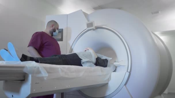 Doktor modern bir klinikte bir hastanın MR veya PET taramasını yapar. Yatakta üç boyutlu tarama makinesinin içindeki kız. Kadın CT taraması yapıyor. — Stok video