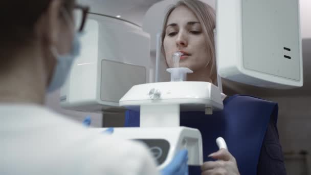 Scansione della mandibola dentale. Ragazza paziente all'interno di uno scanner 3d panaromaniaco di denti. Apparecchiature diagnostiche dispositivo ortopantomografico per denti, risonanza magnetica — Video Stock