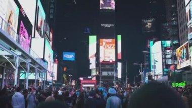 NEW YORK CITY, ABD - 19.03.2021: New York City Night 'taki Famous Times Meydanında Turistler Yürüyor. Geceleri popüler turistik yerler. İnsanlar reklamları izliyor
