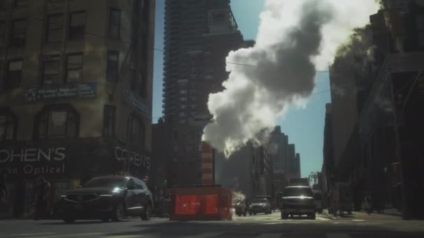 Manhattan, New York - 20.03.2021: Rush Hour Traffic, Manhattan. Overdag straat in New York. Auto 's rijden en stoom komt uit de grond. Normaal uitzicht op de stad, verkeer en doordeweekse dag — Stockvideo