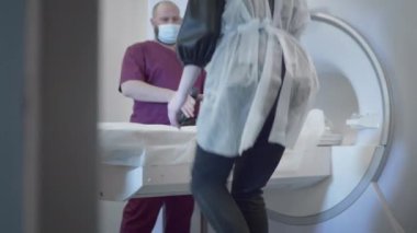 Doktor modern bir klinikte bir hastanın MR veya PET taramasını yapar. Yatakta üç boyutlu tarama makinesinin içindeki kız. Kadın CT taraması yapıyor.