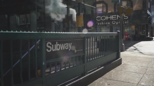 Eingang zur New Yorker U-Bahn. Die Aufschrift Subway auf dem grünen Handlauf an der Treppe. Street View an einem sonnigen Tag. — Stockvideo