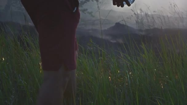 Un voluntario o un niño apaga un fuego salvaje. Vierte agua de una botella de plástico. Selva tropical desastre de incendios forestales, arbustos secos quema, razones de fuego. — Vídeos de Stock