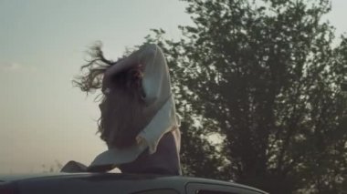 Genç ve güzel bir kız ellerini kaldırarak arabaya biniyor ve arabanın tepesinde bir kadın var. Yolculuk macerası, harika son..