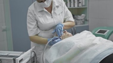 Kozmetik prosedür, operasyon. Doktor sorunlu deriyi sivilcelerle ve sivilcelerle tedavi ediyor. Sağlıklı cilt için lazer