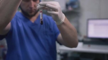 Doktor bir adam test tüpünde kan testi yapar. Laboratuvar ya da hastane ofisinde bilimsel araştırma.