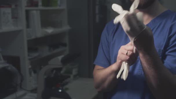 Un doctor científico se pone guantes protectores blancos de goma. Investigación científica en un laboratorio u oficina de un hospital. — Vídeo de stock