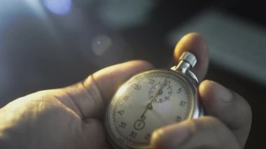 Bir erkeğin elinde kronometre. Bir adam klasik bir spor metalinin ikinci saatinin düğmesine basıyor. Olaydan önce geri sayım, zamanlayıcı