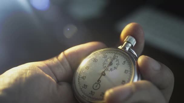 Un cronómetro en la mano de un hombre. Un hombre presiona el botón de un segundo reloj de metal deportivo vintage. Cuenta atrás, temporizador antes del evento — Vídeos de Stock