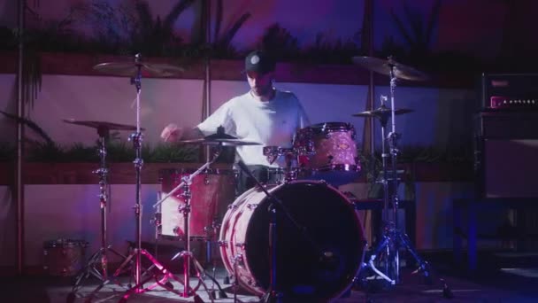 Seorang seniman pria profesional memainkan drum kit. Pertunjukan malam di sebuah studio rekaman instrumen musik. Drummer mengetuk dan mengalahkan, — Stok Video