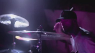 Erkek sanatçı davul çalıyor. Müzikal enstrüman kayıt stüdyosunda gece gösterisi. Davulcu kapıyı çalar ve zille vurur.