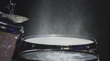 Davulcu davul tokmağı ile ıslak davul ziline vurur ve su yavaş çekimde sıçrar. Müzik aletlerinin kayıt stüdyosunda