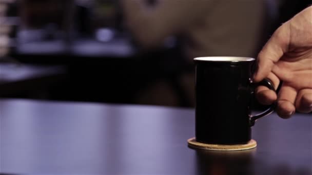 マンの手を置く黒いテーブルの上の黒いマグカップ — ストック動画