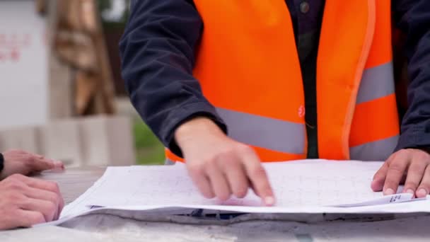 Plan de construcción tendido sobre los ladrillos. los planos — Vídeo de stock