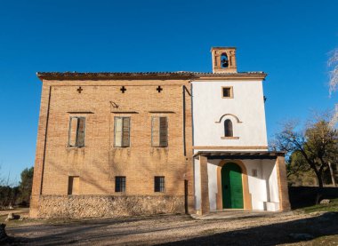 Ormanda çan kulesi ve tuğla duvarları olan küçük bir kilise.