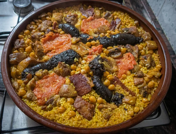  Fırınlanmış pirinç, nohut, kan sosisi ve çeşitli etlerle birlikte, tipik Valencia yemeği (İspanya).).