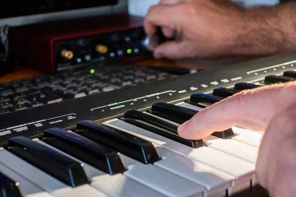 Stüdyoda Midi klavyesiyle müzik çalan müzisyen..