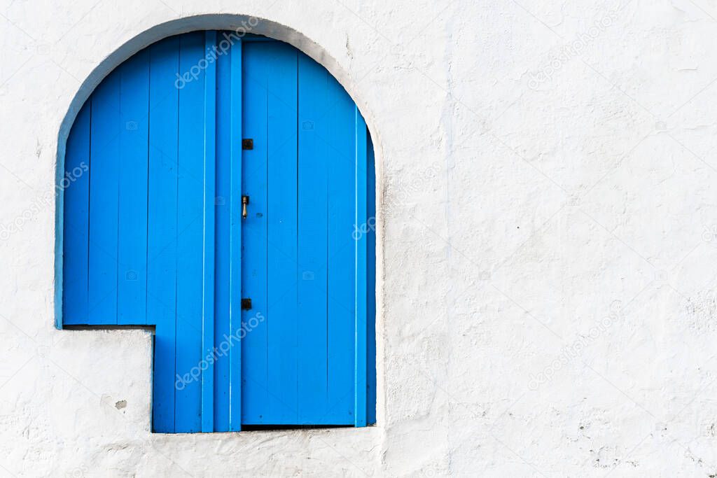Blue door in a house with a white facade and Mediterranean style.