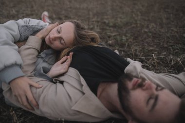 Birbirine aşık bir çift, bulutlu bir havada açık soya fasulyesi tarlasında yürür ve bol bol sarılır.
