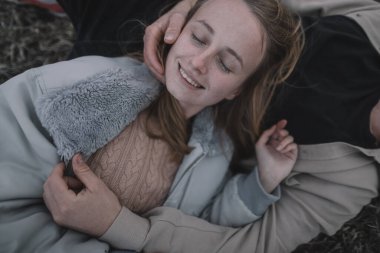 Birbirine aşık bir çift, bulutlu bir havada açık soya fasulyesi tarlasında yürür ve bol bol sarılır.