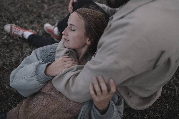 влюбленная пара гуляет на открытом соевом поле вечером в облачную погоду и обнимается много