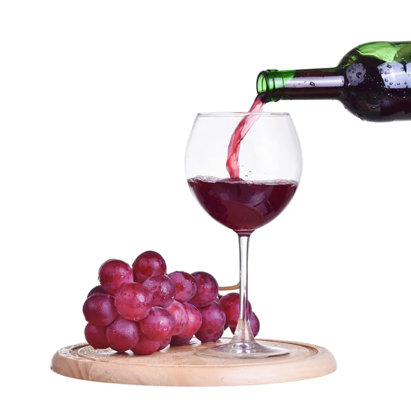 Isolierte Flasche mit Rotwein, Glas und Traube auf Holzteller — Stockfoto