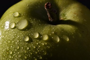 Su ile ıslak yeşil makro apple siyah arka plan üzerine düşer