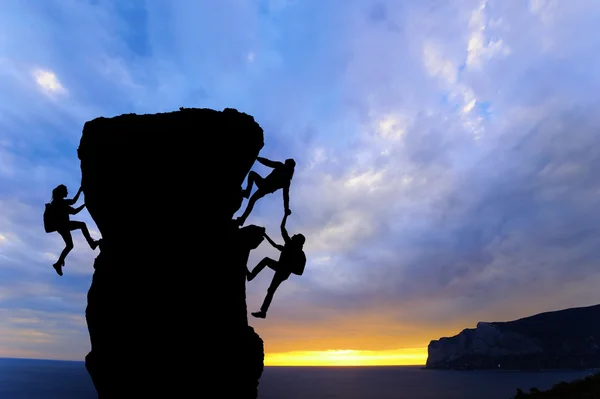 Ortak çalışma ekip çalışması iki adam yolcuları birbirimize üstüne bir dağcılık takımı, güzel bir günbatımı manzara yardımcı Telifsiz Stok Fotoğraflar
