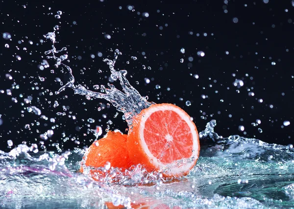 Makro su sıçrama üzerinde greyfurt. Su damlaları ile sulu greyfurt