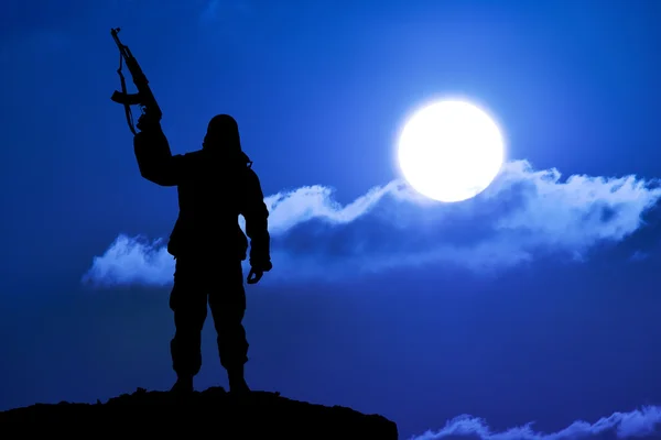 Sylwetka żołnierza wojskowych lub oficera z broni o zachodzie słońca. strzał, trzymając pistolet, kolorowe niebo, Góra, tło — Zdjęcie stockowe