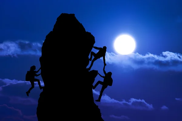 Ortak çalışma çalışması iki adam gezginler ve kız üzerine bir dağcılık takımı, güzel bir günbatımı manzara birbirimize yardımcı