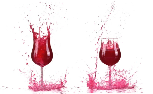 Dos copas con cóctel de vino tinto, salpicadura de vino tinto, vino vertiendo sobre la mesa aislado sobre fondo blanco, gran salpicadura alrededor —  Fotos de Stock