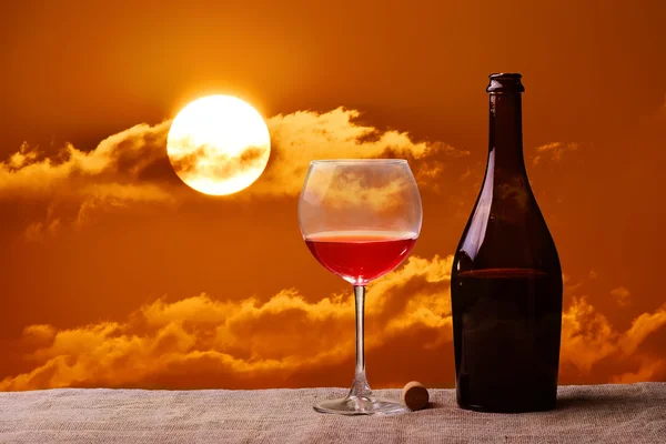 Bottle and glass of red wine on the linen table against the sea or ocean — Stock Photo, Image