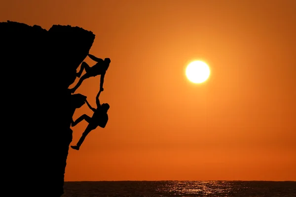 Ortak çalışma çalışması iki adam gezginler ve kız üzerine bir dağcılık takımı, güzel bir günbatımı manzara birbirimize yardımcı