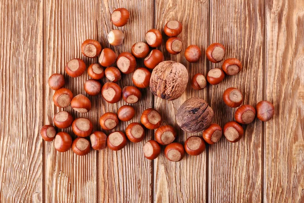 Cerrar avellanas y nueces sobre tabla de madera Nueces enteras y avellanas sobre fondo de madera Fotos de stock libres de derechos