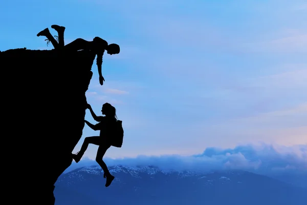 Ortak çalışma ekip çalışması iki kişi adam ve kız yolcuları birbirimize üstüne bir dağcılık takımı, güzel bir günbatımı manzara yardımcı.