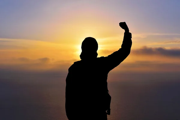 Young man standing with arms outstretched at sunset — Stock Photo, Image